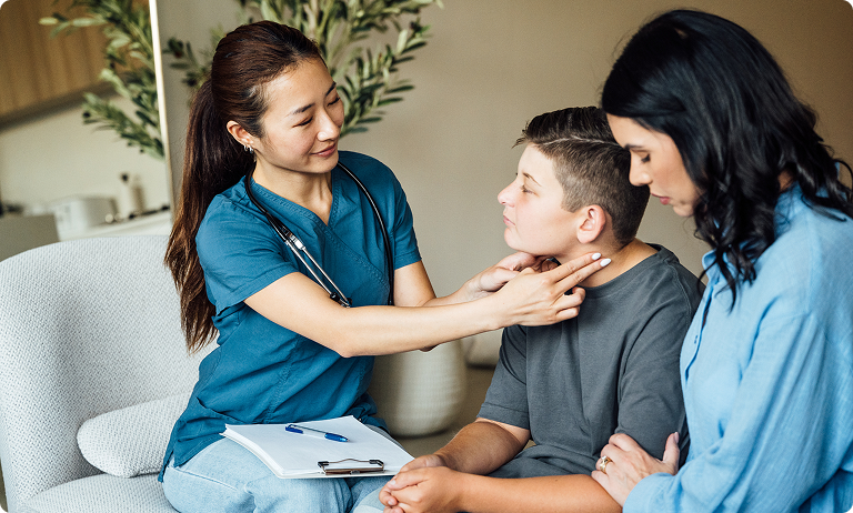 Nurse examining boy's throat with mother