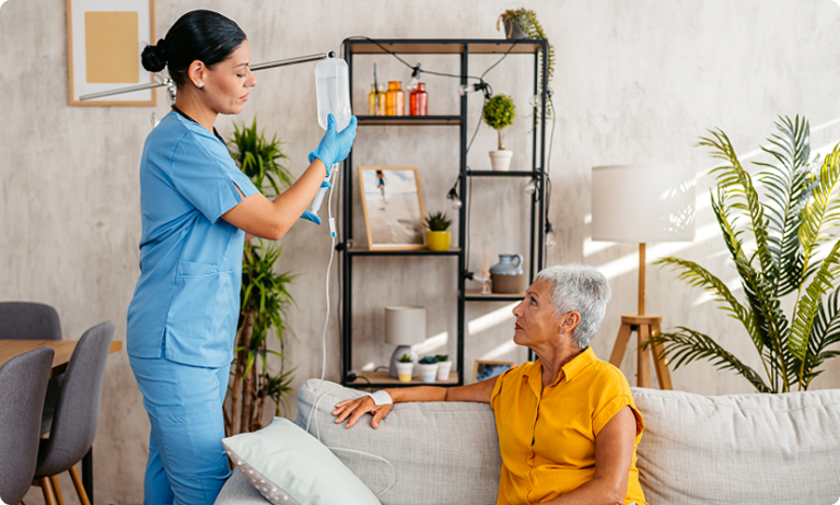 Caregiver adjusting IV bag for elderly woman