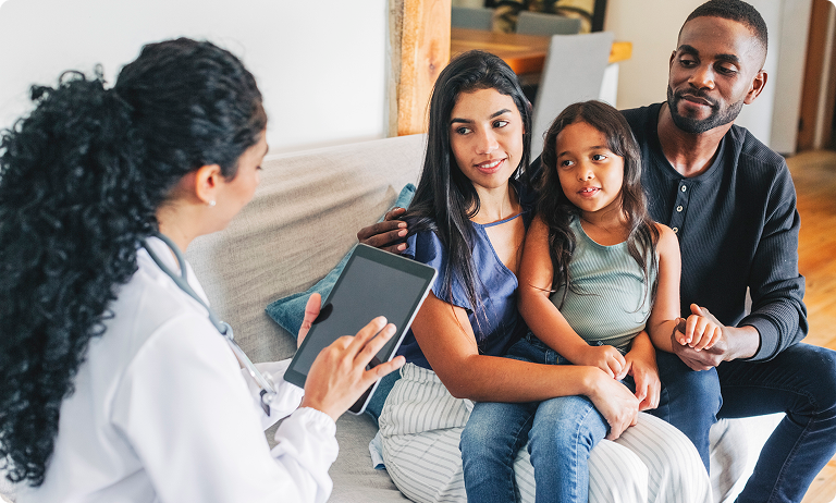 Doctor consulting parents with child at home