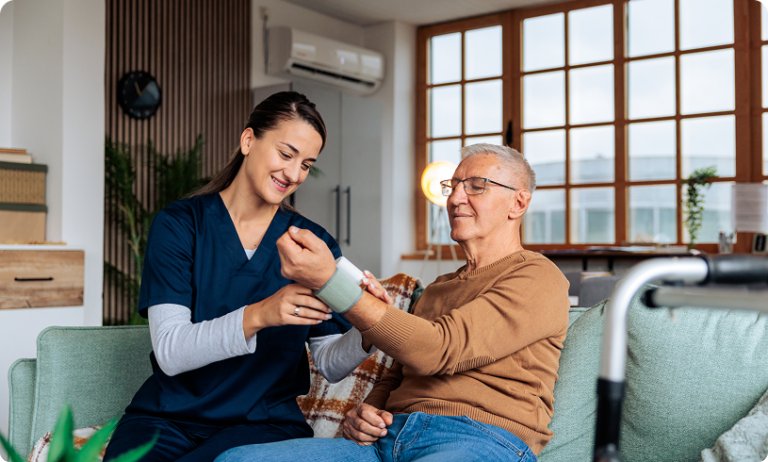 Caregiver measuring elderly man's blood pressure
