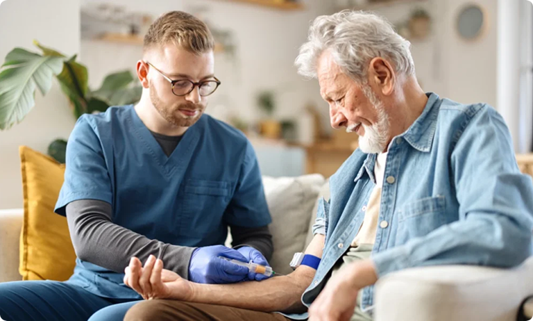 Healthcare professional drawing blood from elderly man